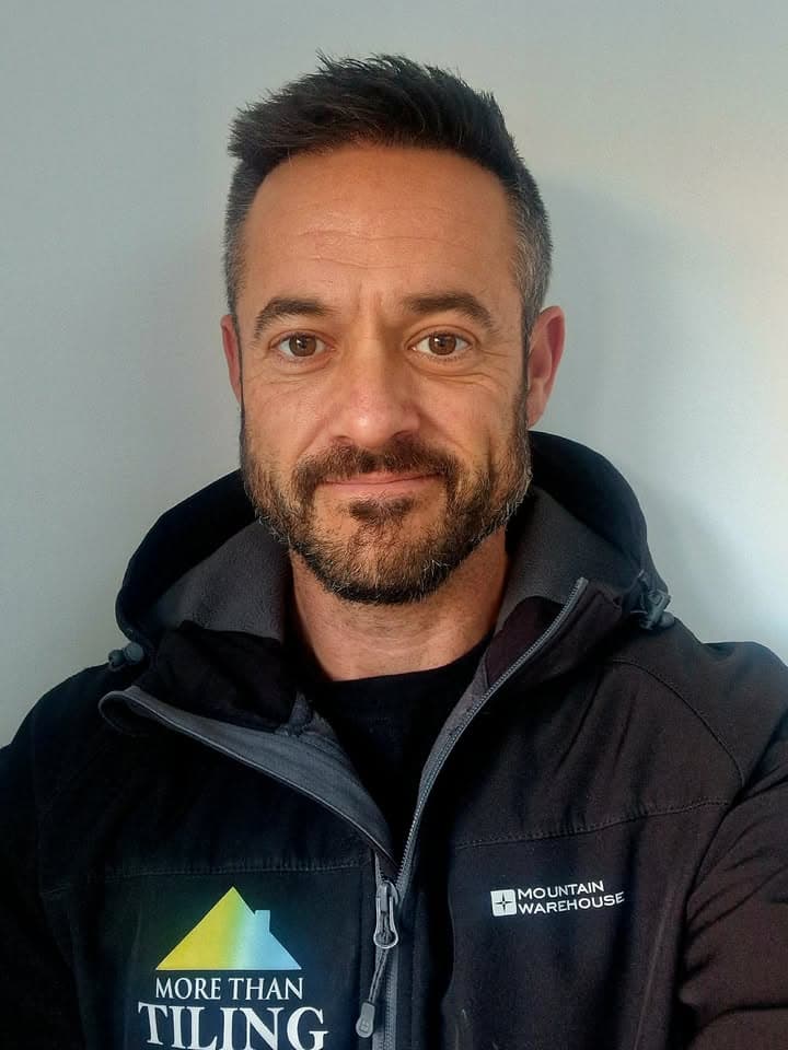 Wesley, owner of MoreThan Tiling, wearing a branded MoreThan Tiling fleece